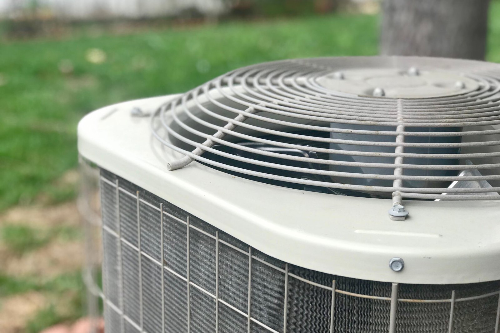 Close-up of an outdoor air conditioner condenser and fan grille